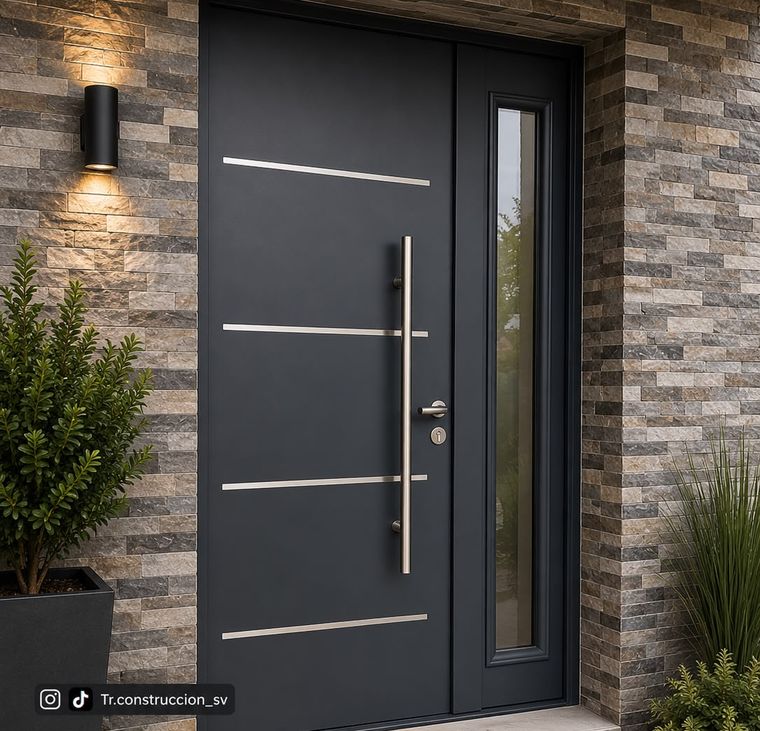 Puerta metálica gris grafito con cuatro franjas horizontales de acero inoxidable, jaladera tubular vertical y vitral lateral