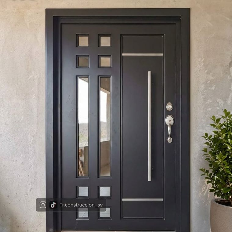 Puerta metálica negra con vidrios cuadrados y dos vitrales verticales, con jaladera tubular larga de acero